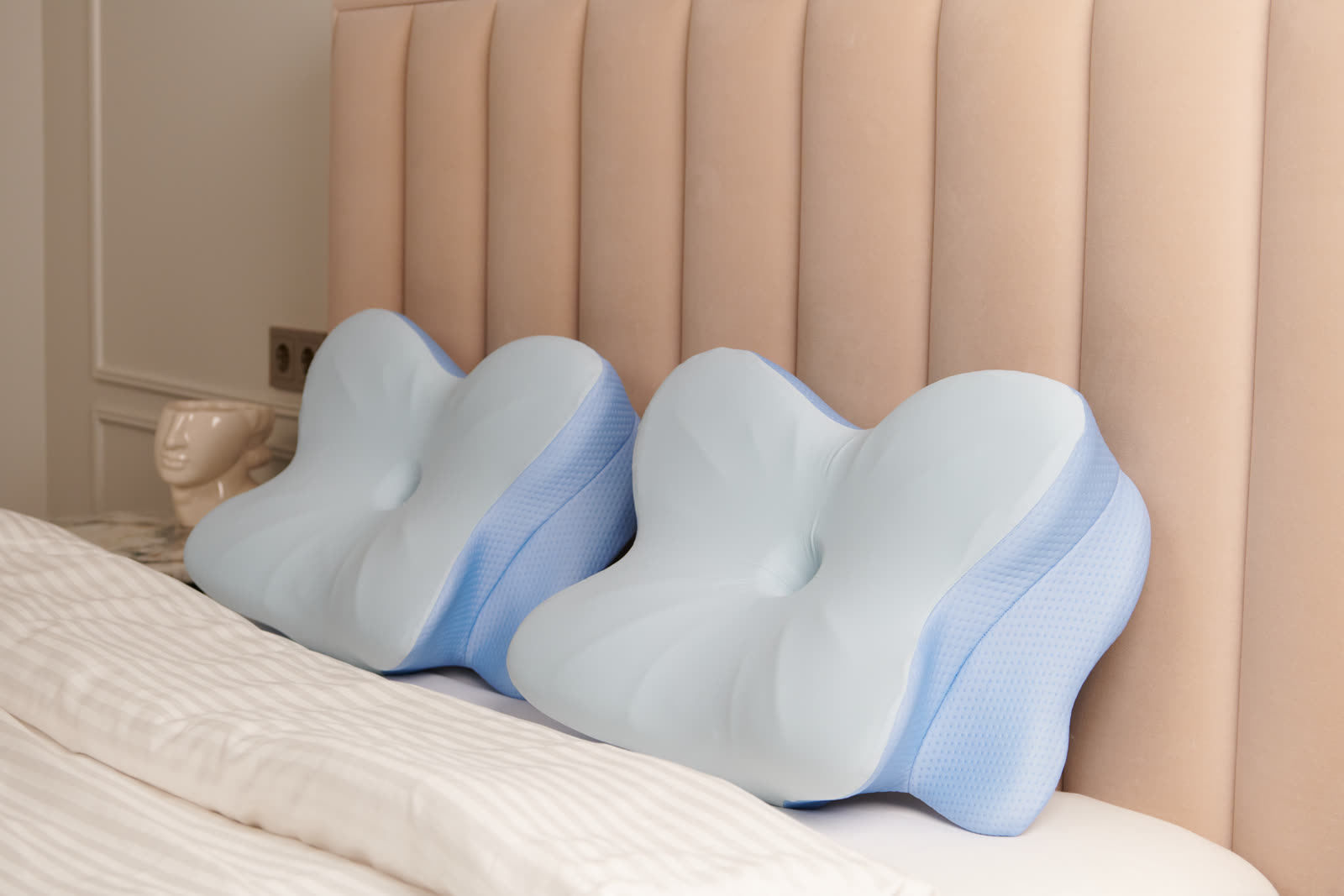 Butterfly-contour memory foam pillows resting on a bed